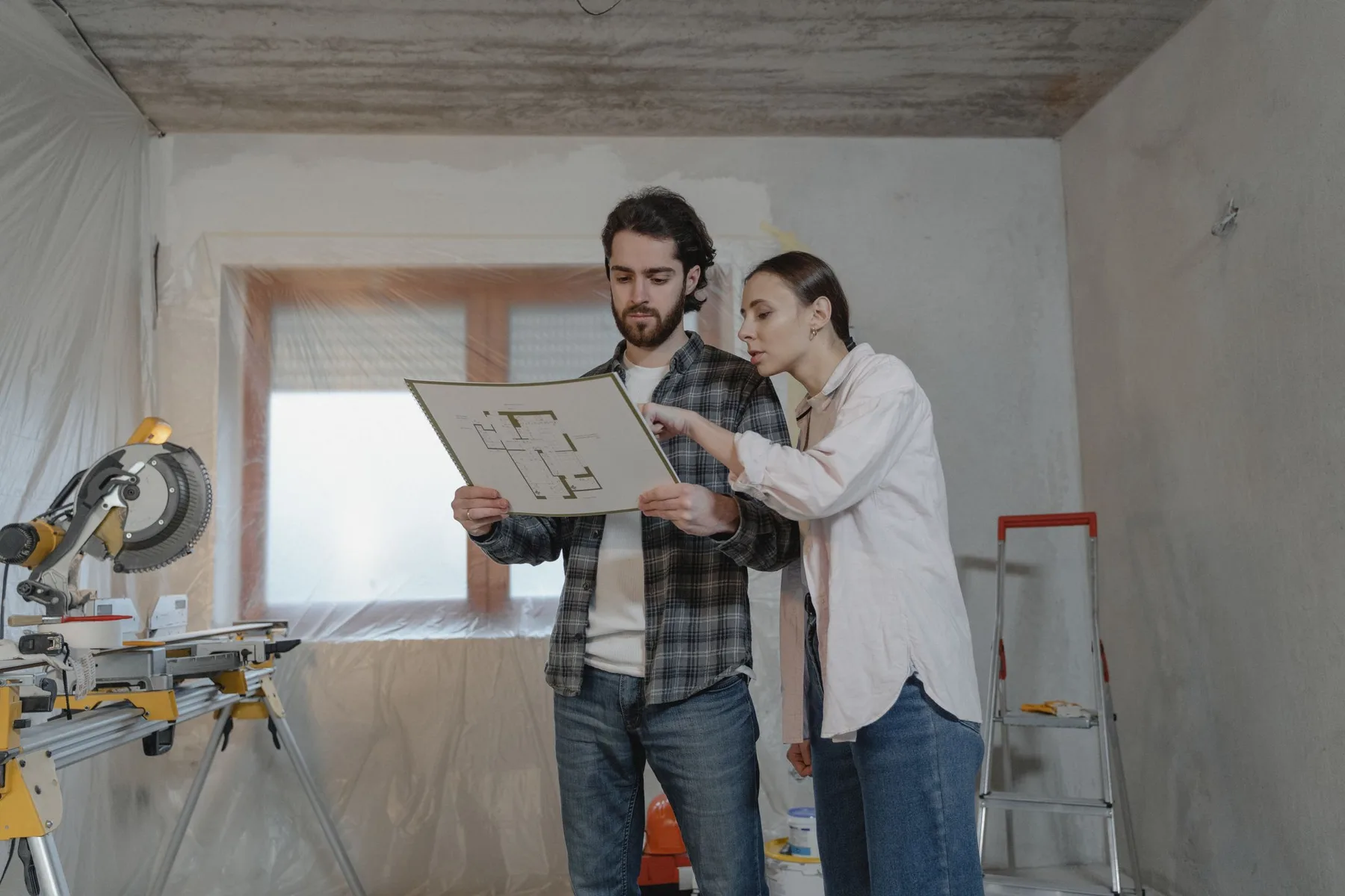 Contractor and homeowner reviewing renovation plans at a residential job site