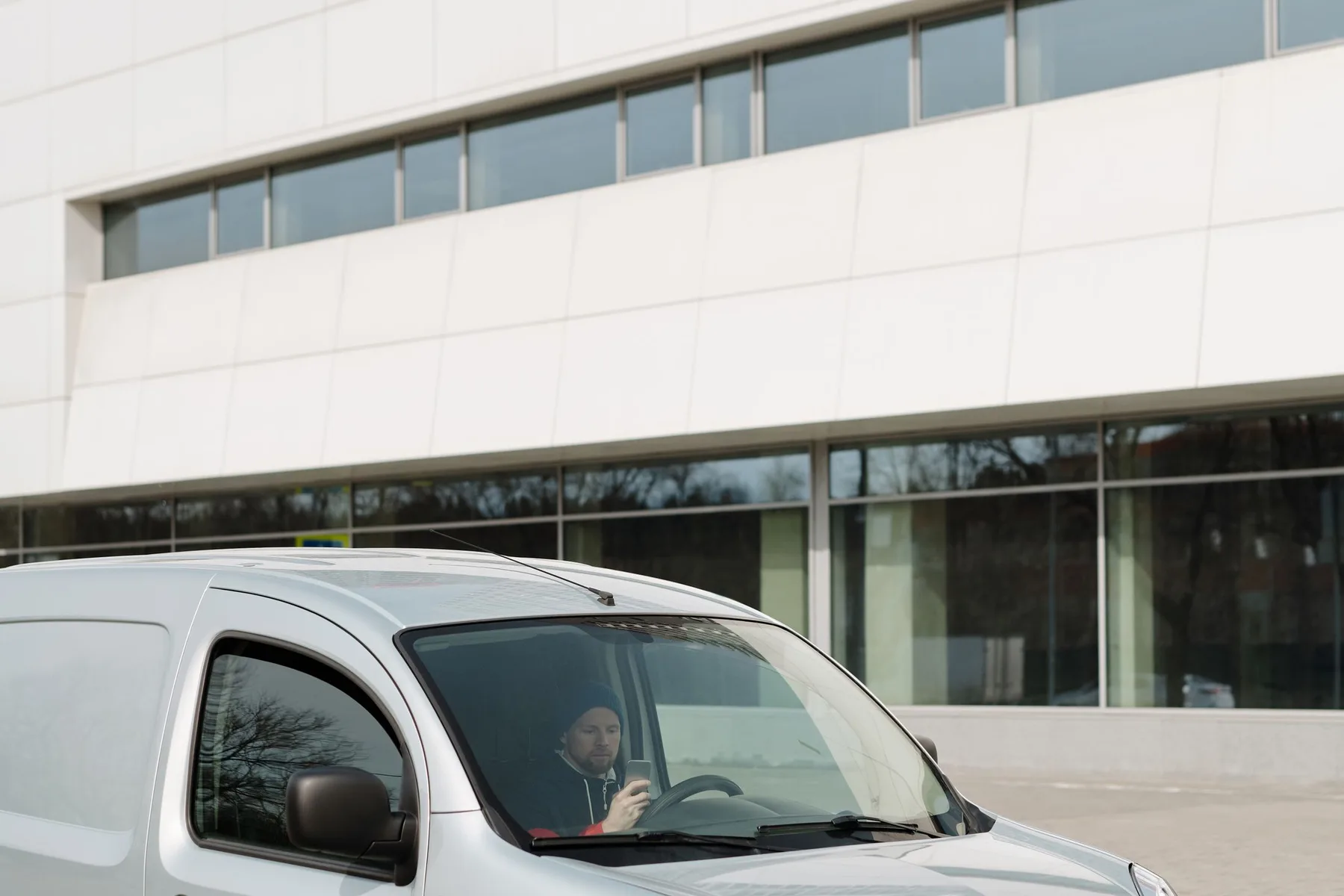 Service professional using a phone inside a work van