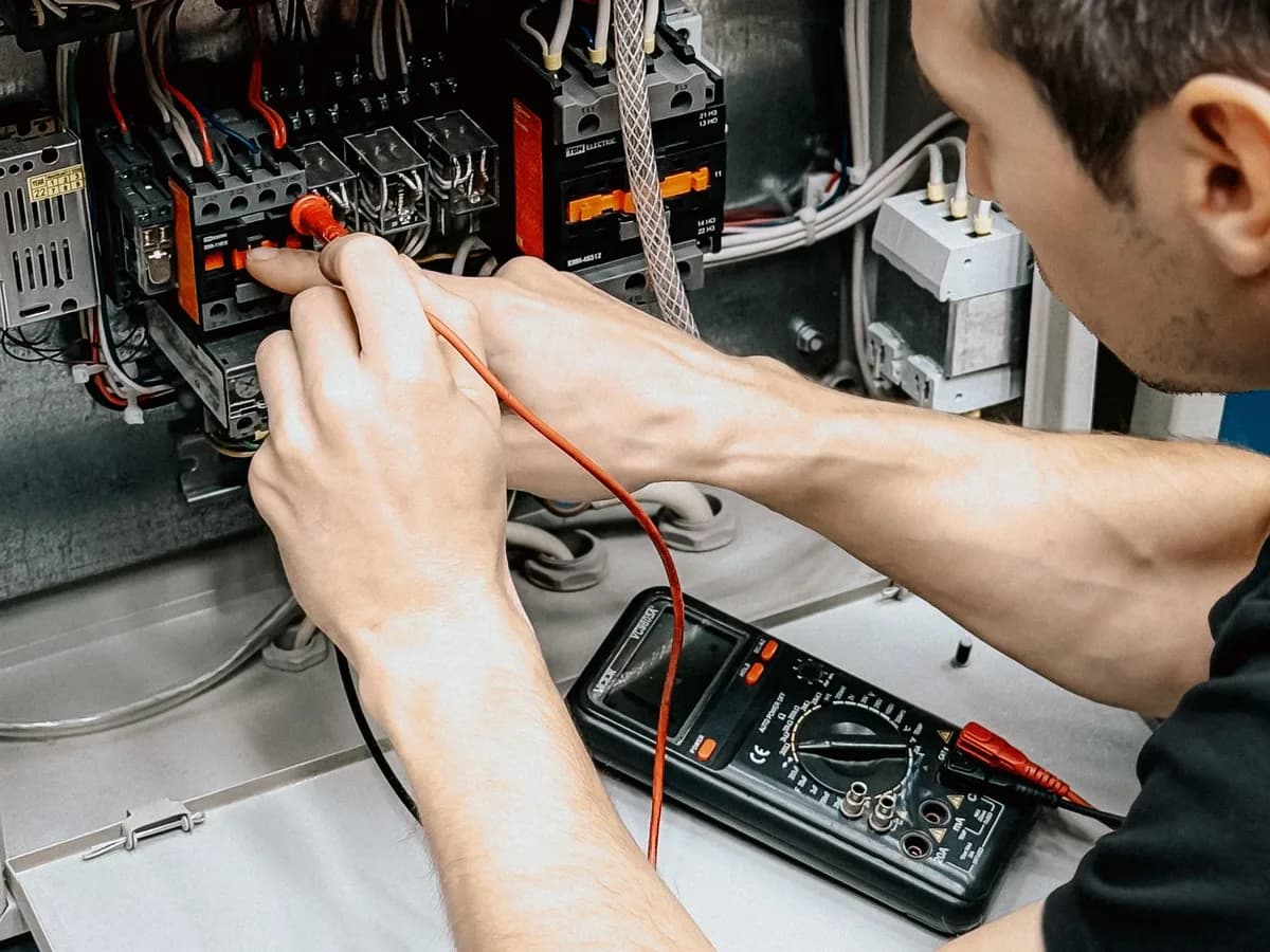 Electrician testing an electrical panel with a multimeter