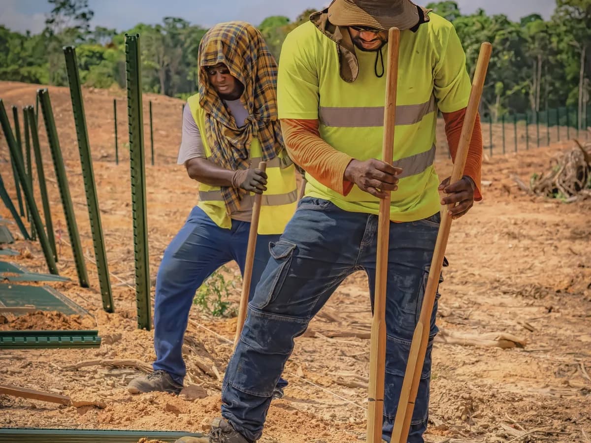 Fencing contractors installing posts at a residential job site