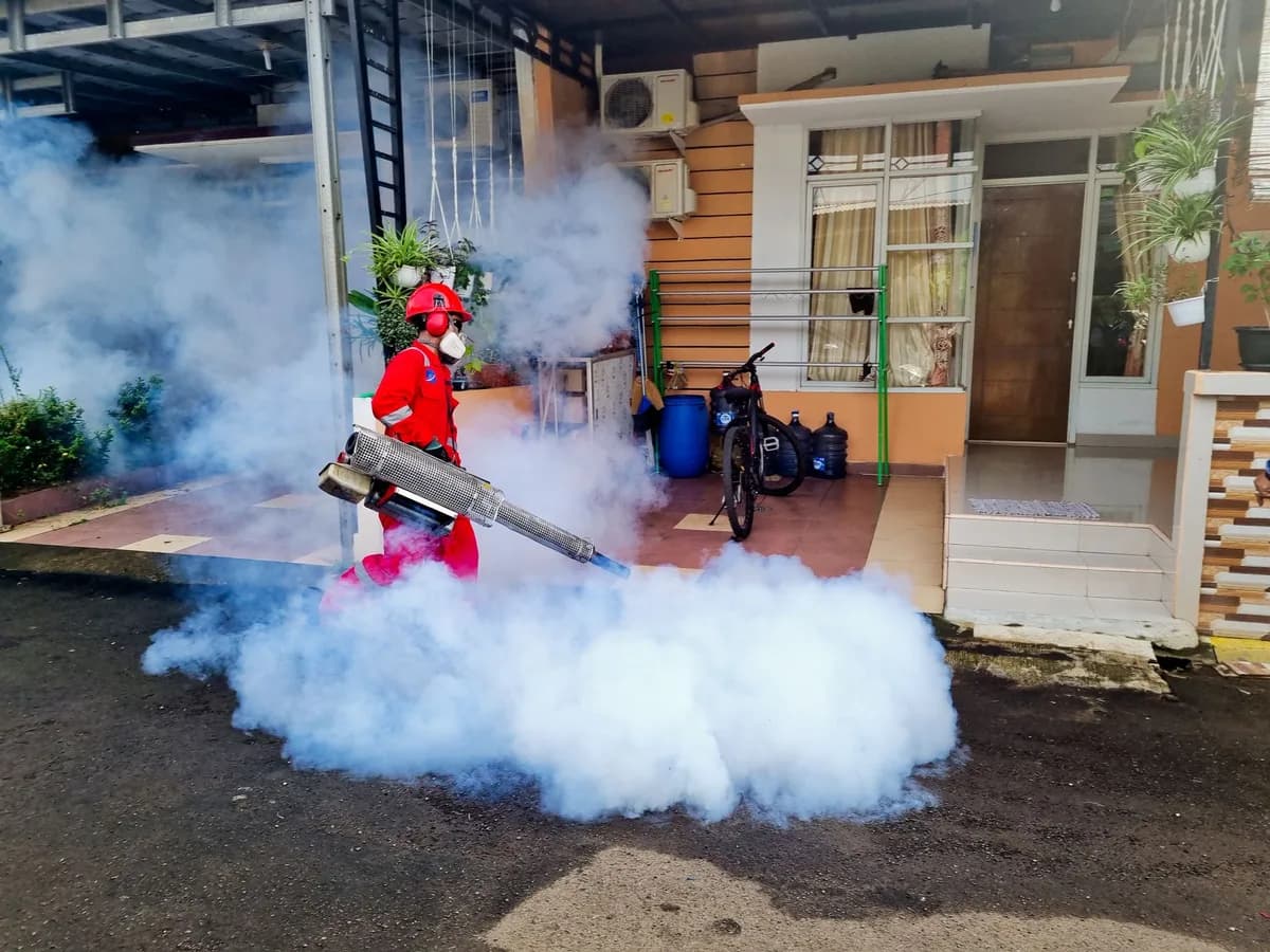 Pest control technician treating the exterior of a home